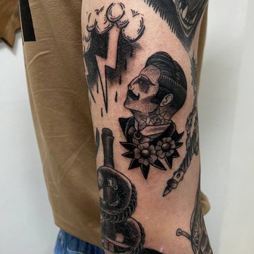 Oberarm mit mehreren schwarzen Traditional-Tattoos